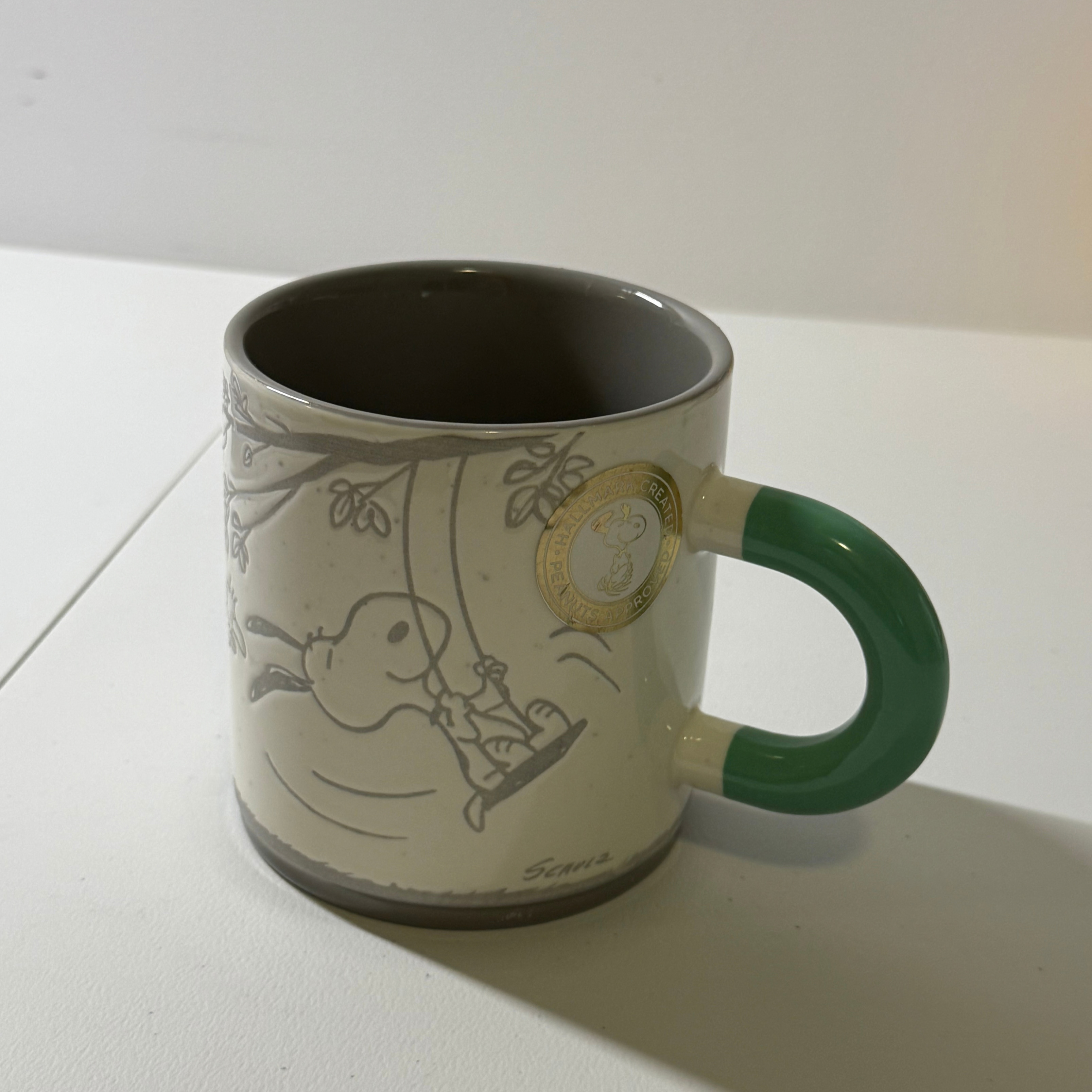 Reference photo of a ceramic mug with a green handle