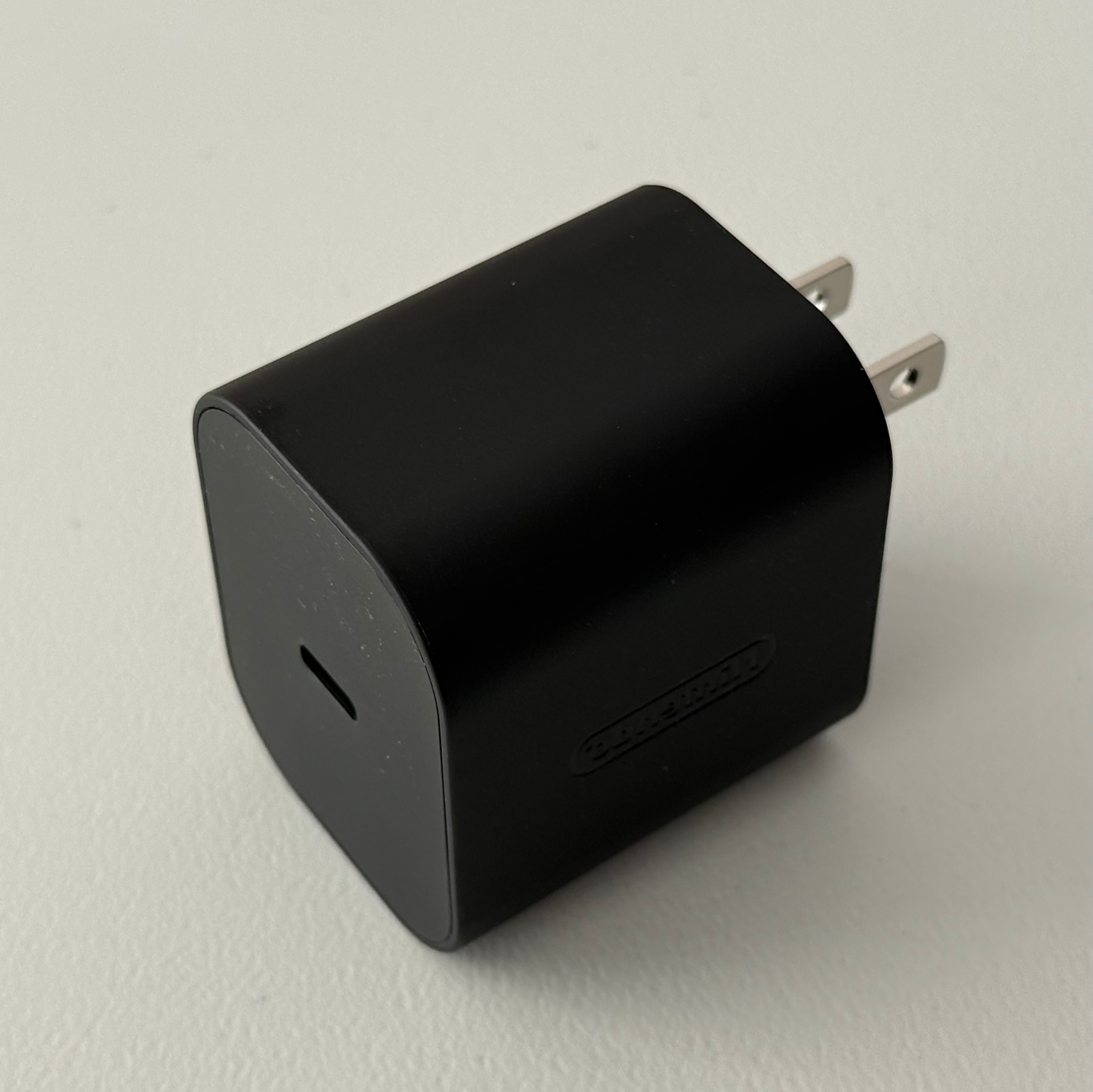 Reference photo of a black wall charger with two metal plugs
